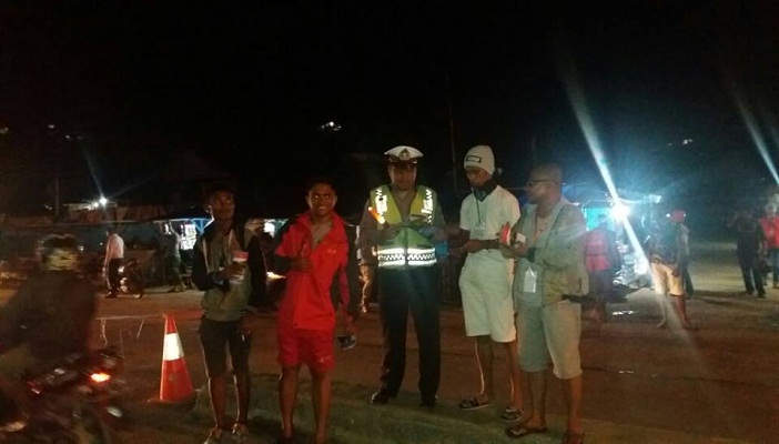 Seorangpolisi yang kebagian-brosur-parwisata-kei-kecil ketika rombongan OMK Kei Kecil tiba di Sorong